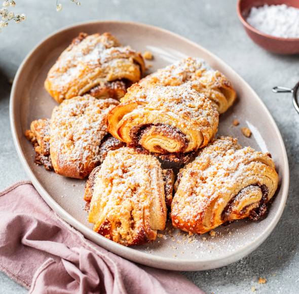 Franzbrötchen mit Streuseln und Puderzucker