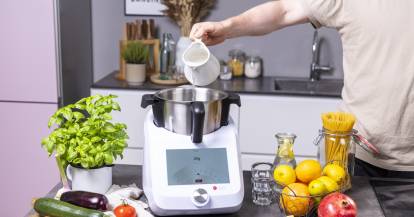 Hand gießt Wasser in Mixbehälter des Monsieur Cuisine smart