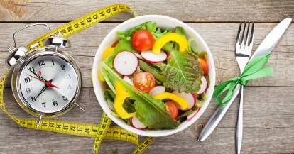 Weiße Schüssel mit Salat und einem Wecker daneben