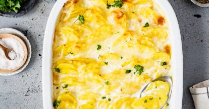 Kartoffelgratin in einer Auflaufform mit Löffel