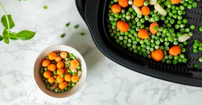 TK-Erbsen und -Karotten liegen zum Auftauen im Dampfgaraufsatz des Monsieur Cuisine