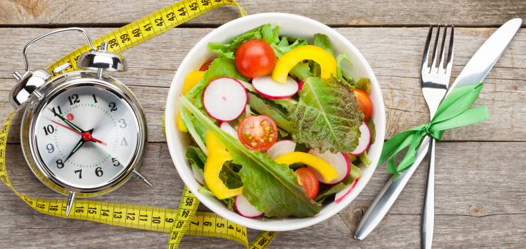 Weiße Schüssel mit Salat und einem Wecker daneben
